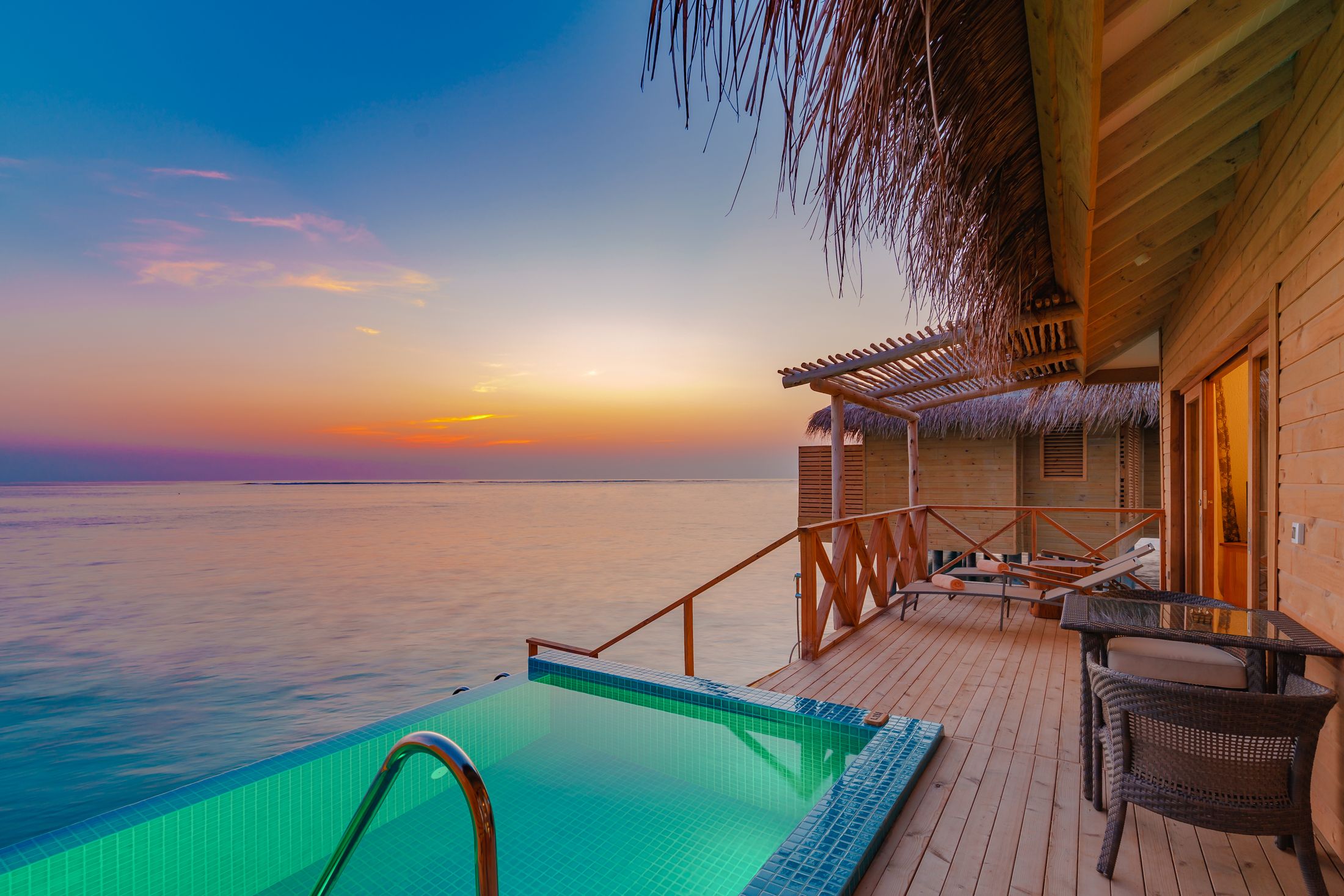 A villa pool over the water at sunset