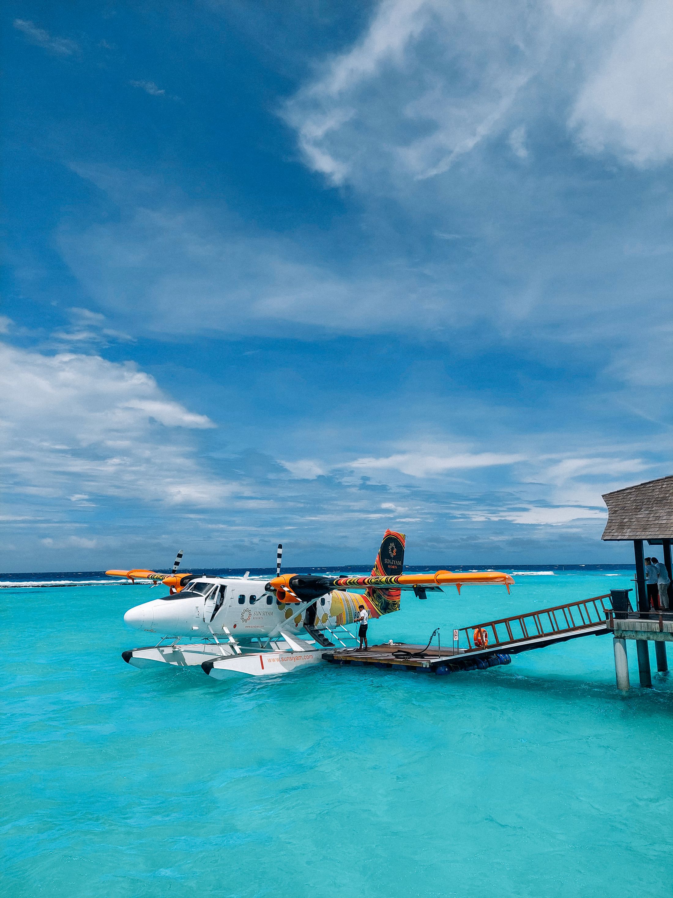 A seaplane moored at a floating dock in blue water