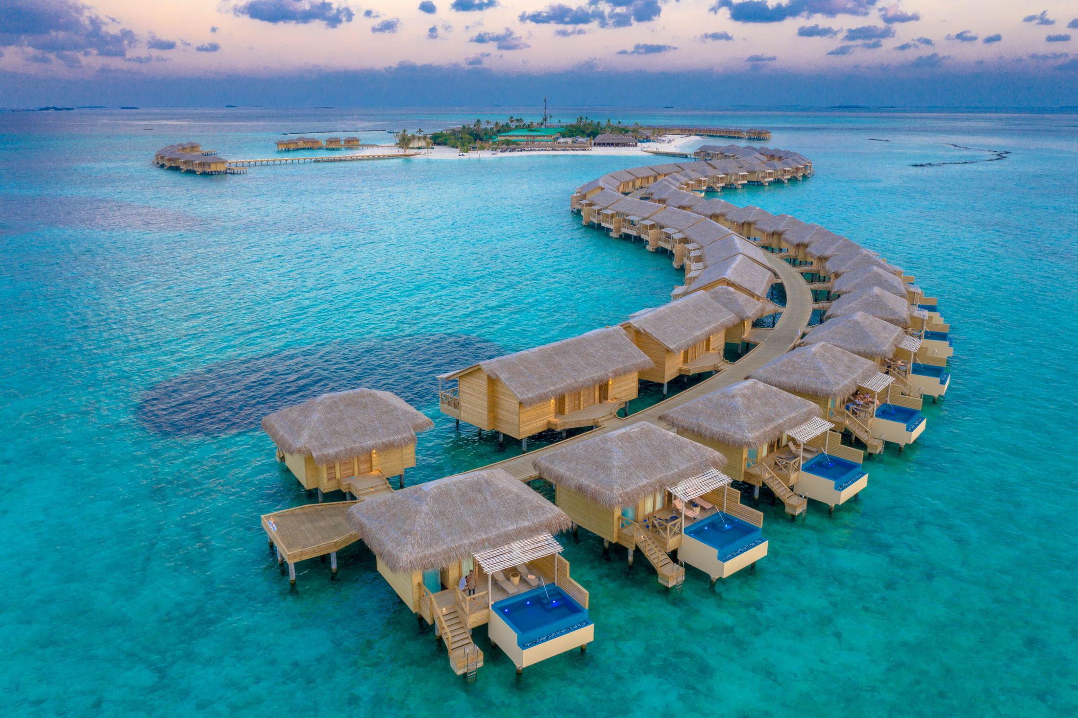 A curving line of overwater villas with private pools